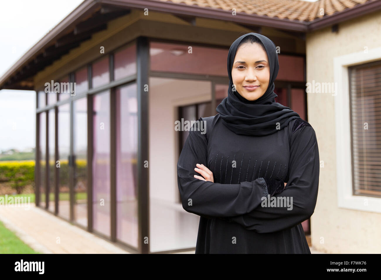 Bellissimo centro donna orientale in piedi di fronte a casa sua Foto Stock