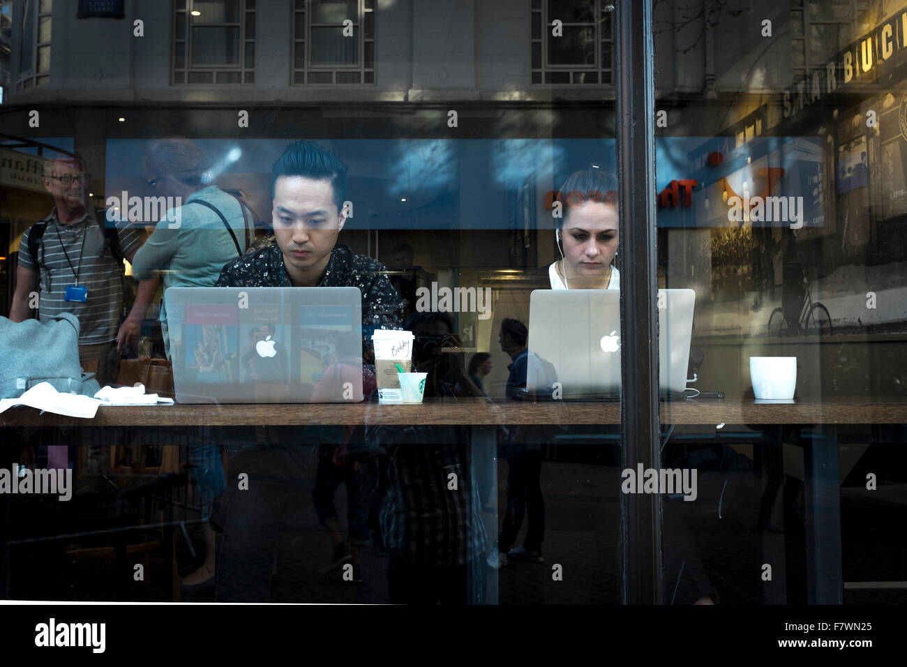 Giovane uomo e donna che utilizza computer Mac Apple in un cafe, Birmingham, Regno Unito Foto Stock