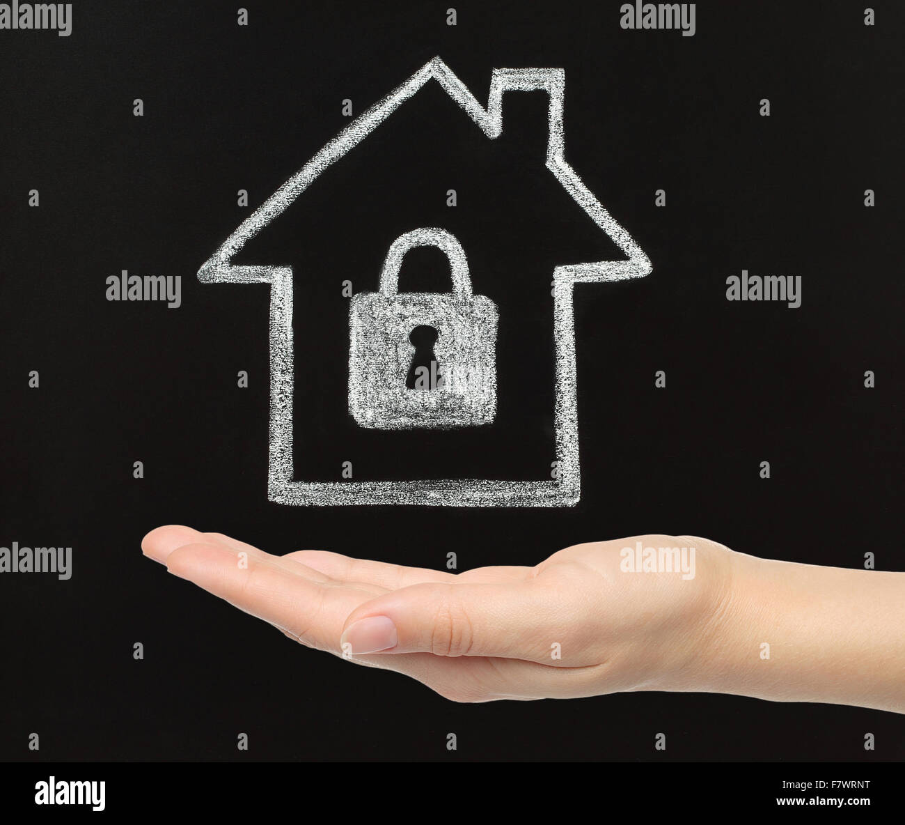 Home Concetto di sicurezza. Chalk house con la donna mano su sfondo blackboard Foto Stock