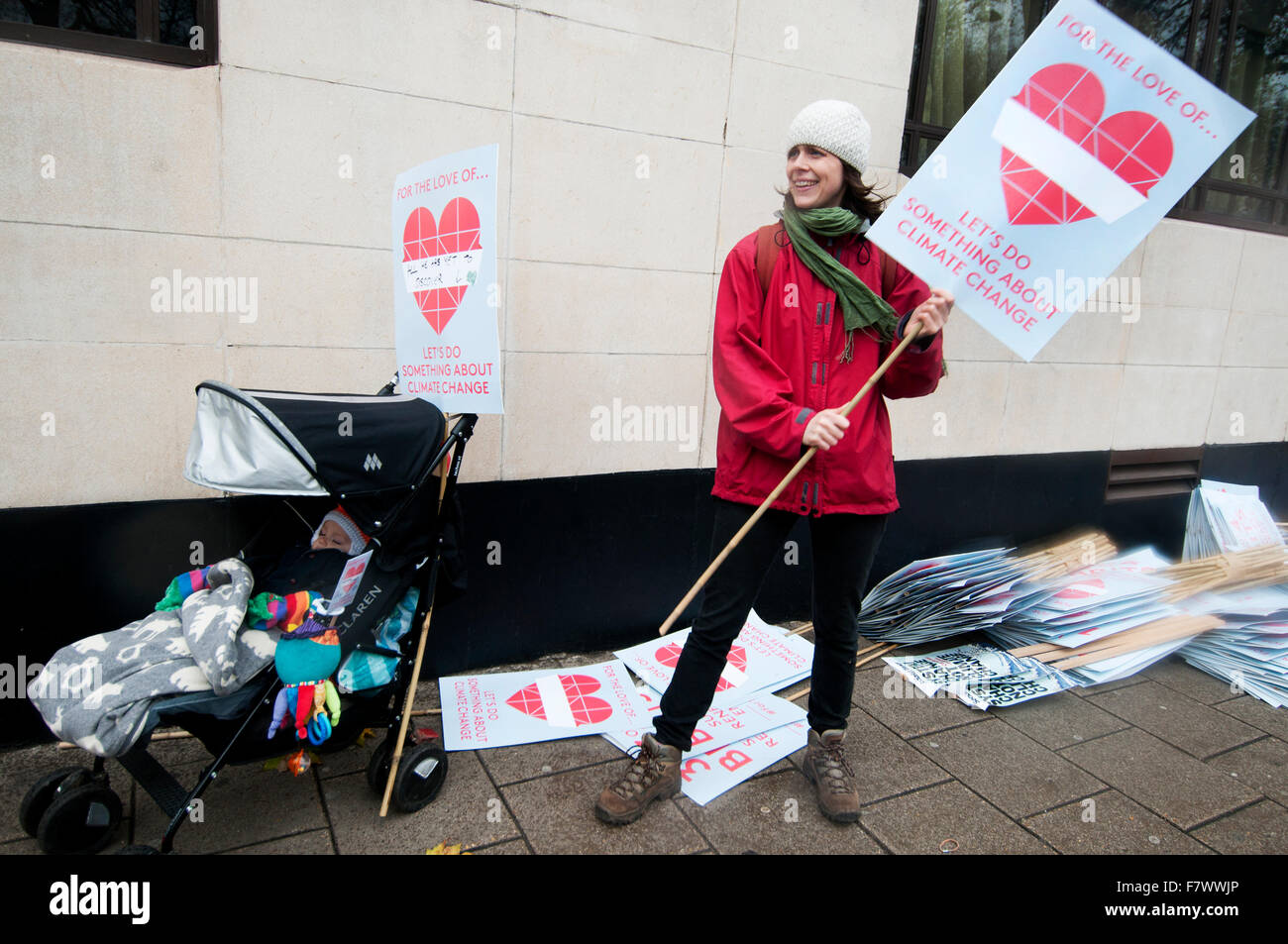 Marzo a demand leader globale di prendere provvedimenti per combattere il cambiamento climatico. Una madre con il suo bambino in una sedia push mani cartelloni Foto Stock