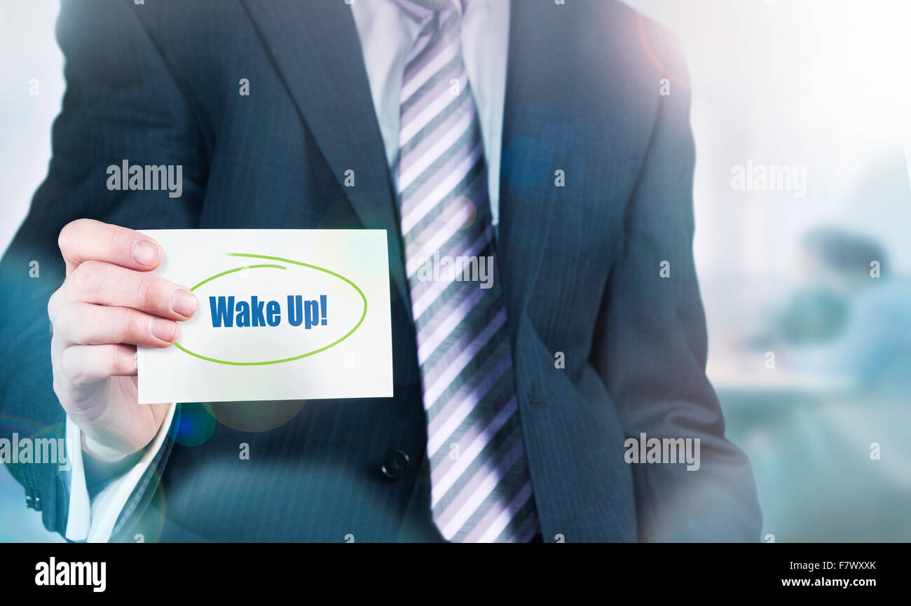 Imprenditore in possesso di una carta con Wake Up! Scritto su di esso. Foto Stock