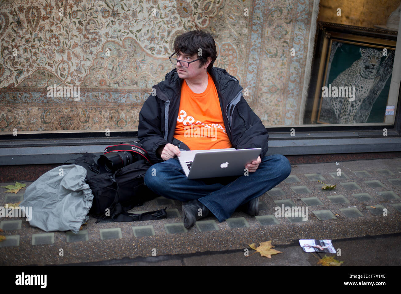 Marzo a demand leader globale di prendere provvedimenti per combattere il cambiamento climatico. Un fotografo downloads sul marciapiede in Piccadilly Foto Stock