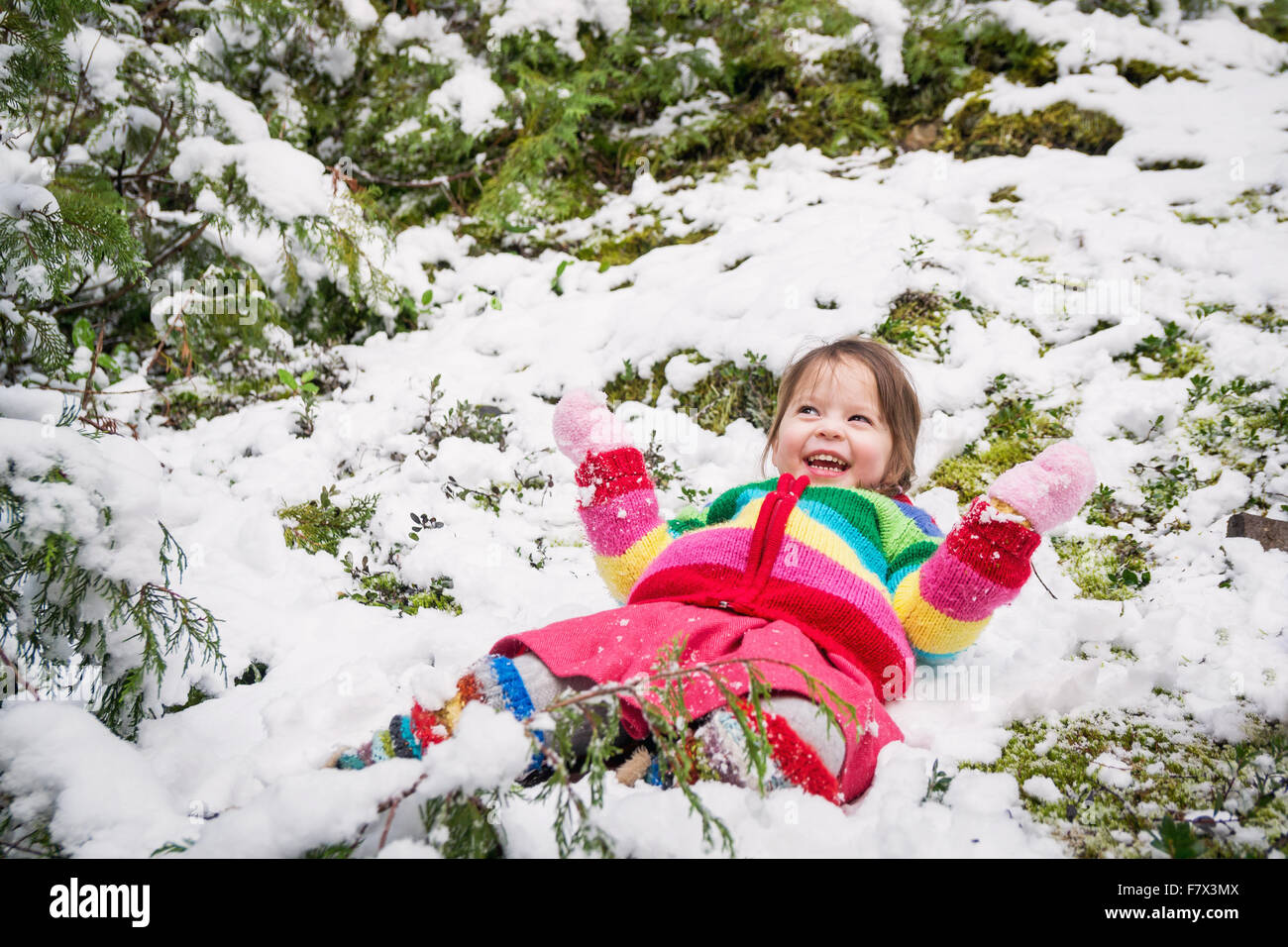 Sorridente ragazza distesa nella neve Foto Stock