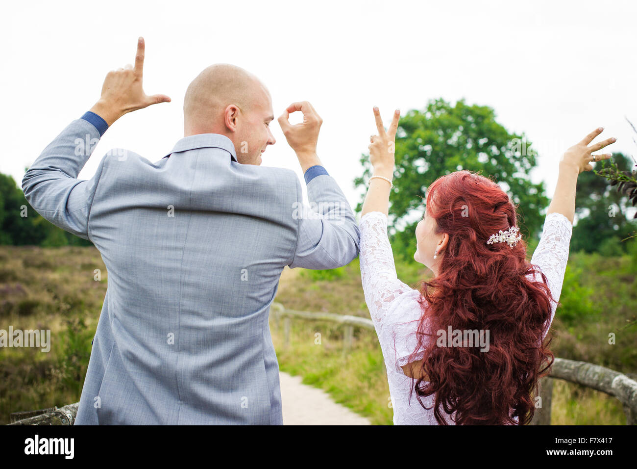 Sposa giovane ortografia della parola amore con le loro mani Foto Stock