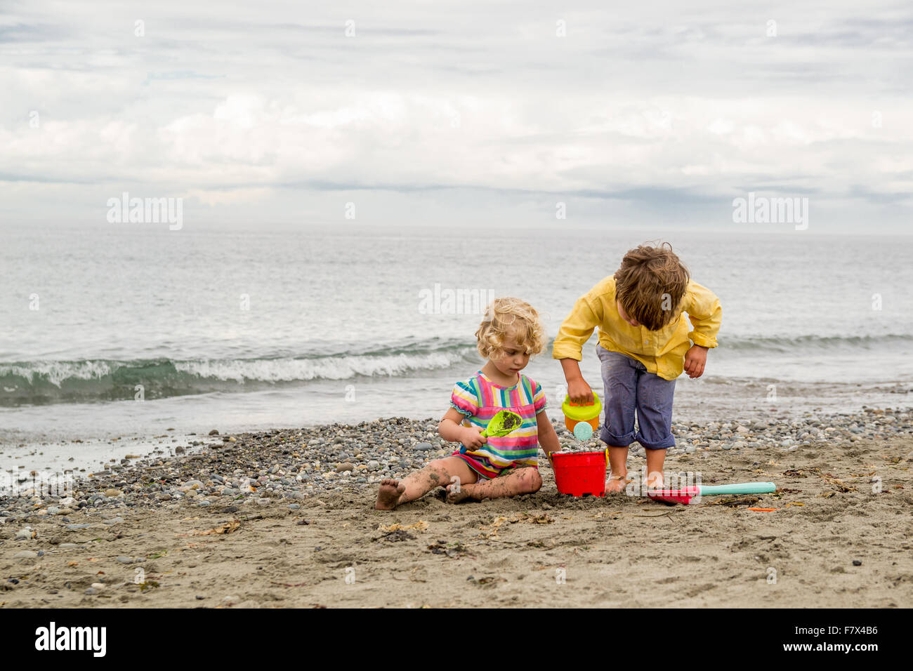 Un ragazzo e una ragazza giocando sulla spiaggia Foto Stock