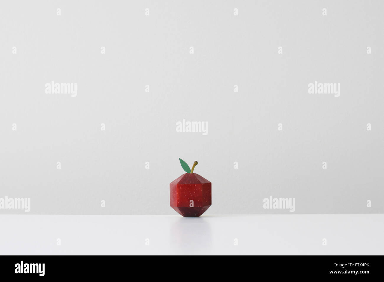 Red apple infilate in forma geometrica imitando la carta origami Foto Stock