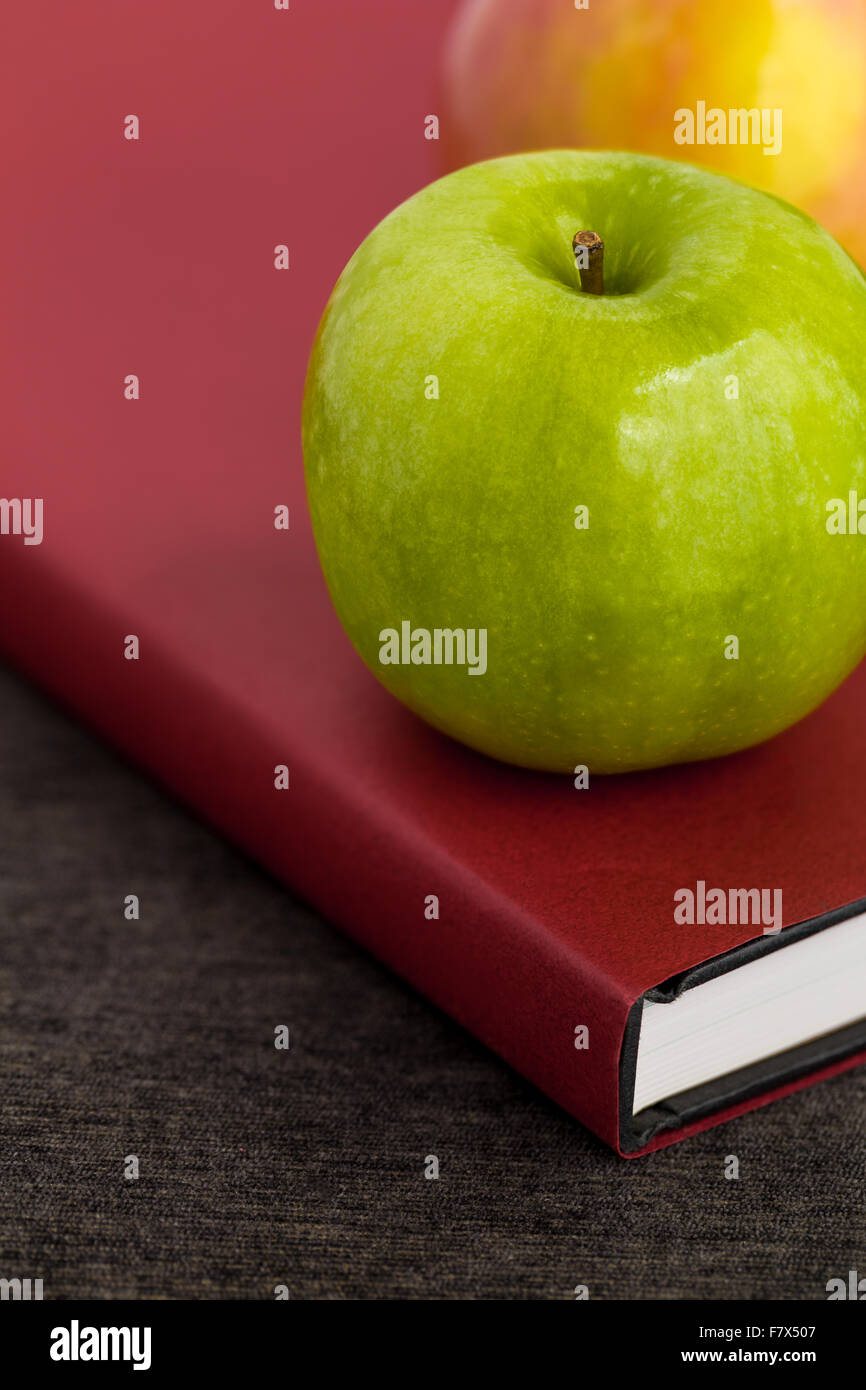 Verde mela con libro illustrato la conoscenza e la saggezza del concetto. Foto Stock