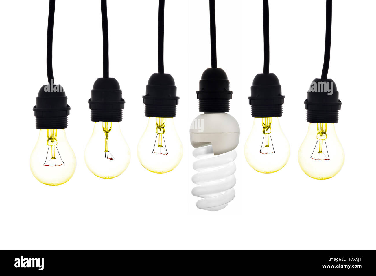 Una lampadina a basso consumo tra lampadine tungsteno su sfondo bianco Foto Stock