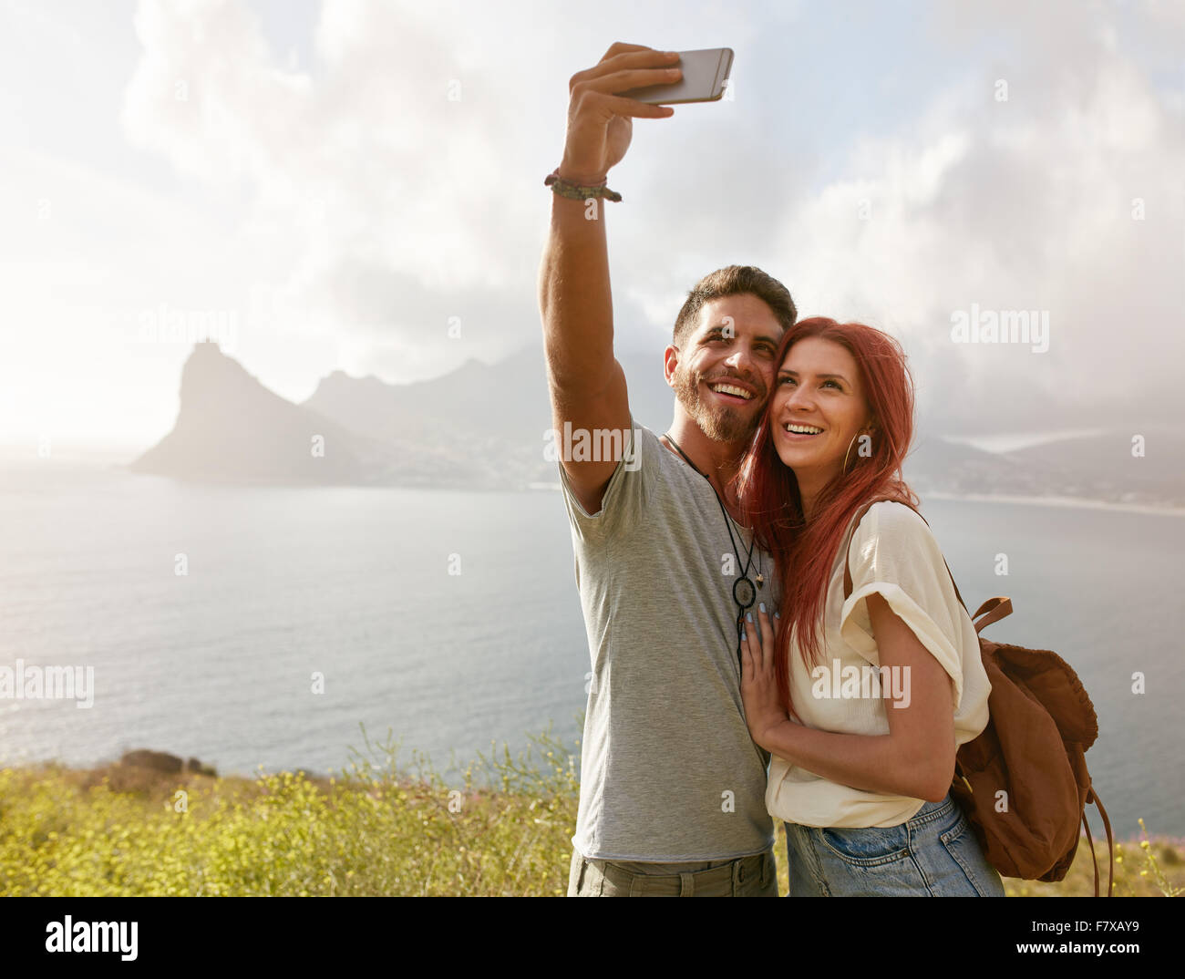 Allegro una giovane coppia in vacanza facendo selfie con smart phone. Coppia giovane dalla baia di prendere un ritratto selfie con cella pho Foto Stock
