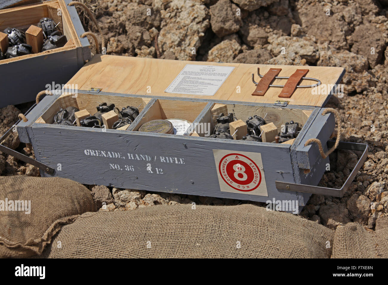 Una scatola piena di numero 36 mulini Granate a mano con stagno dei detonatori nel centro a prescindere dalle granate e una chiave a filo Foto Stock