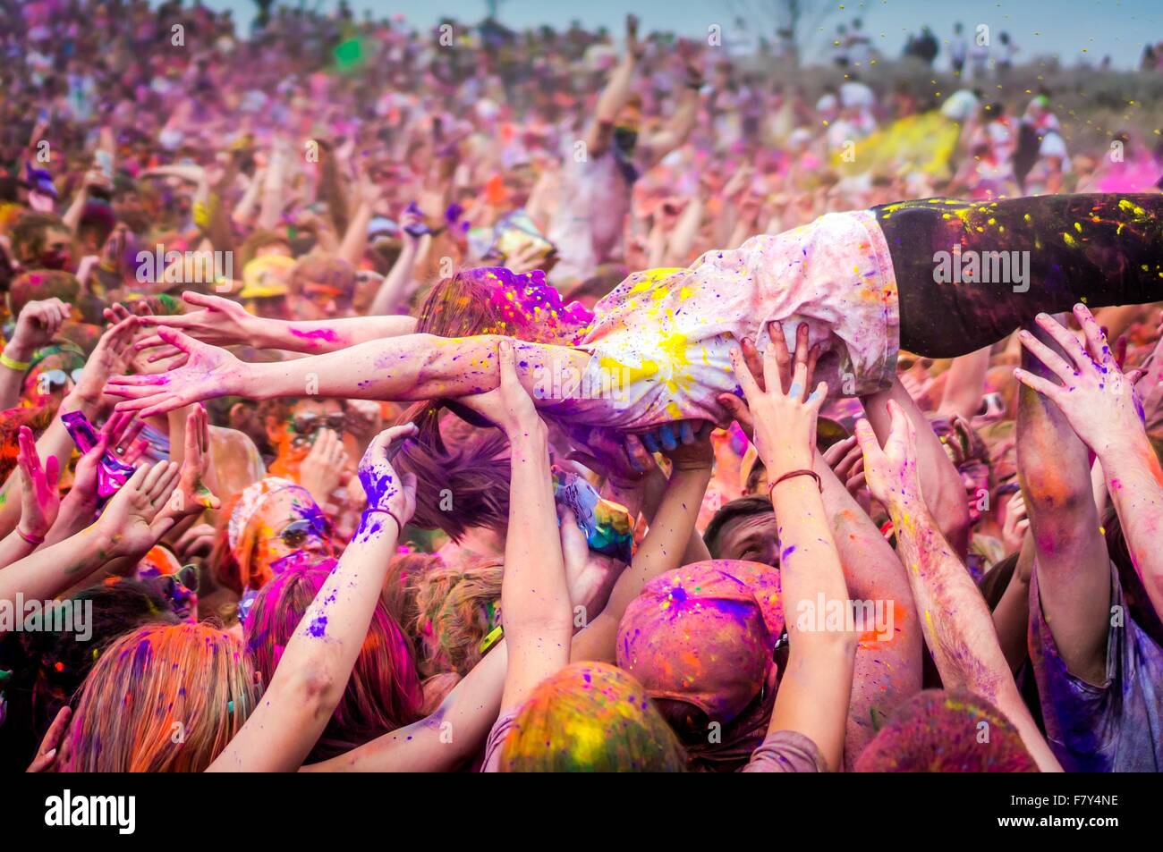 Una giovane donna coperto di polvere colorata body surf sulla folla durante il Holi festival dei colori a Sri Sri Radha Krishna Temple Marzo 29, 2014 in spagnolo forcella, Utah. Il festival segue la tradizione indiana di Holi ed attrae più di 80.000 persone. Foto Stock