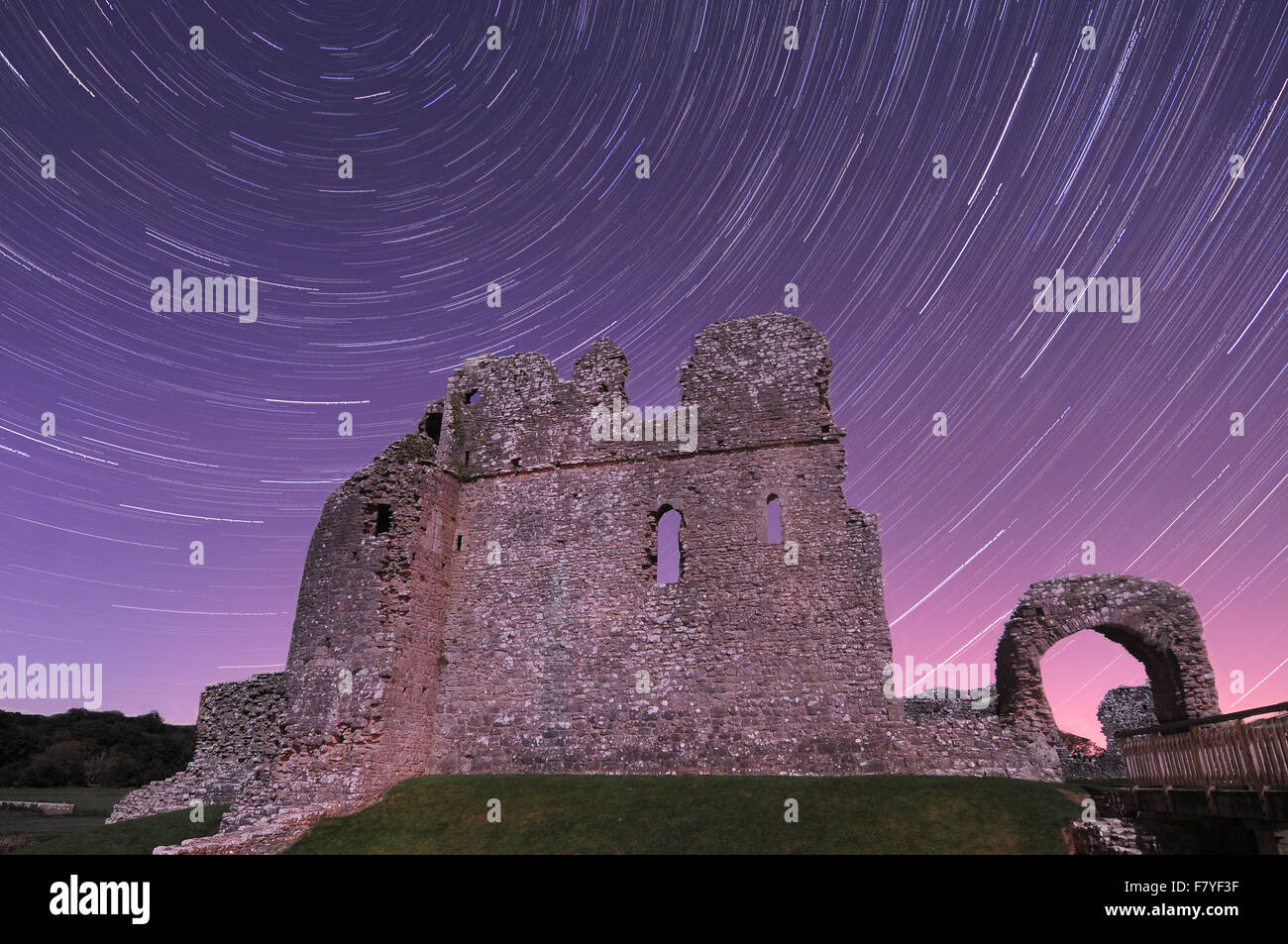 Ogmore Castle nel Vale of Glamorgan di notte con tracce stellari da una lunga esposizione. Foto Stock