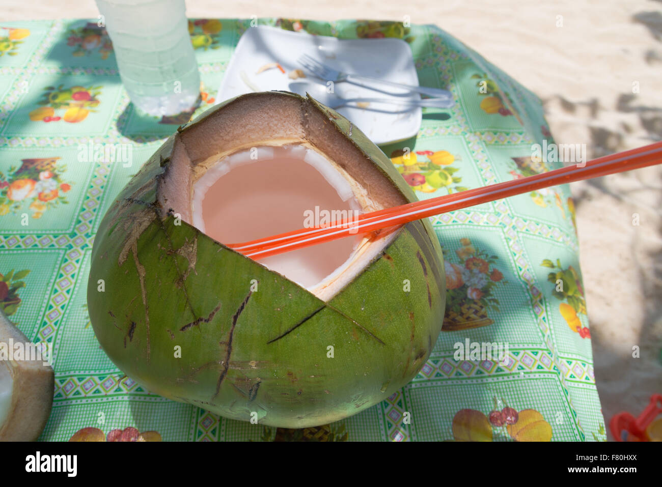 Rinfrescanti drink di noce di cocco con una cannuccia rossa Foto Stock