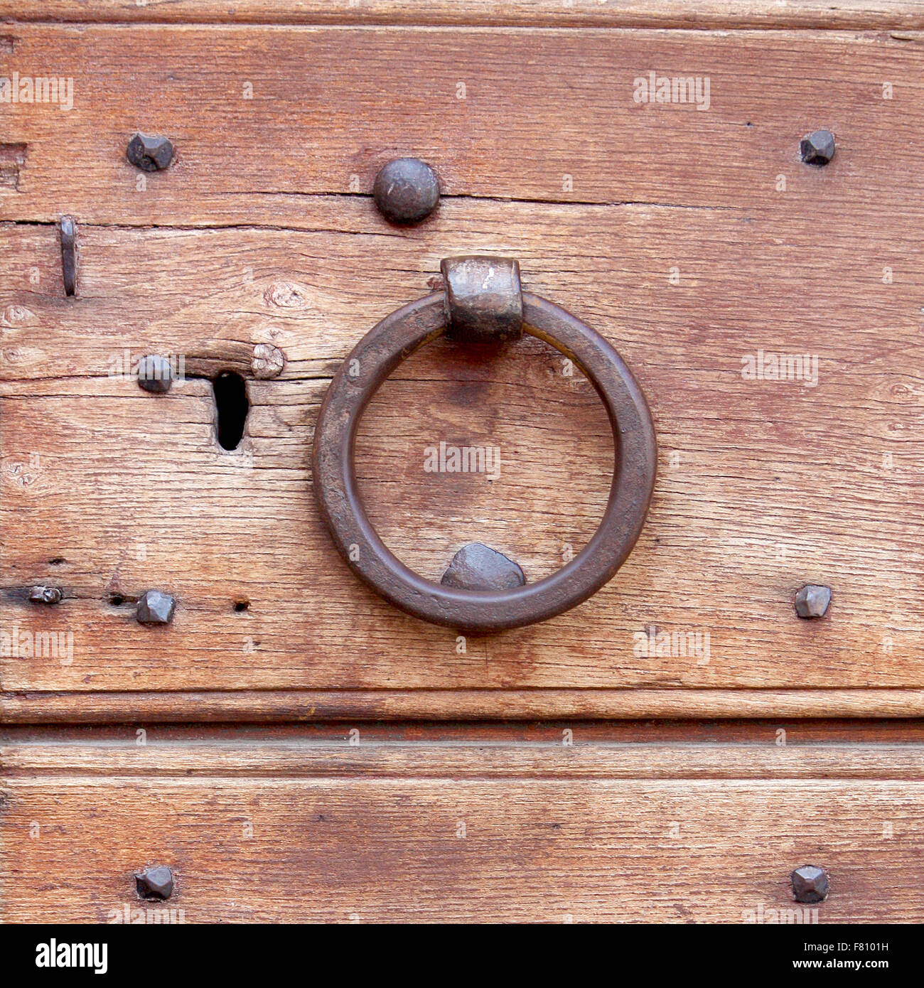 Vecchio respingente circolare su una porta di legno Foto Stock