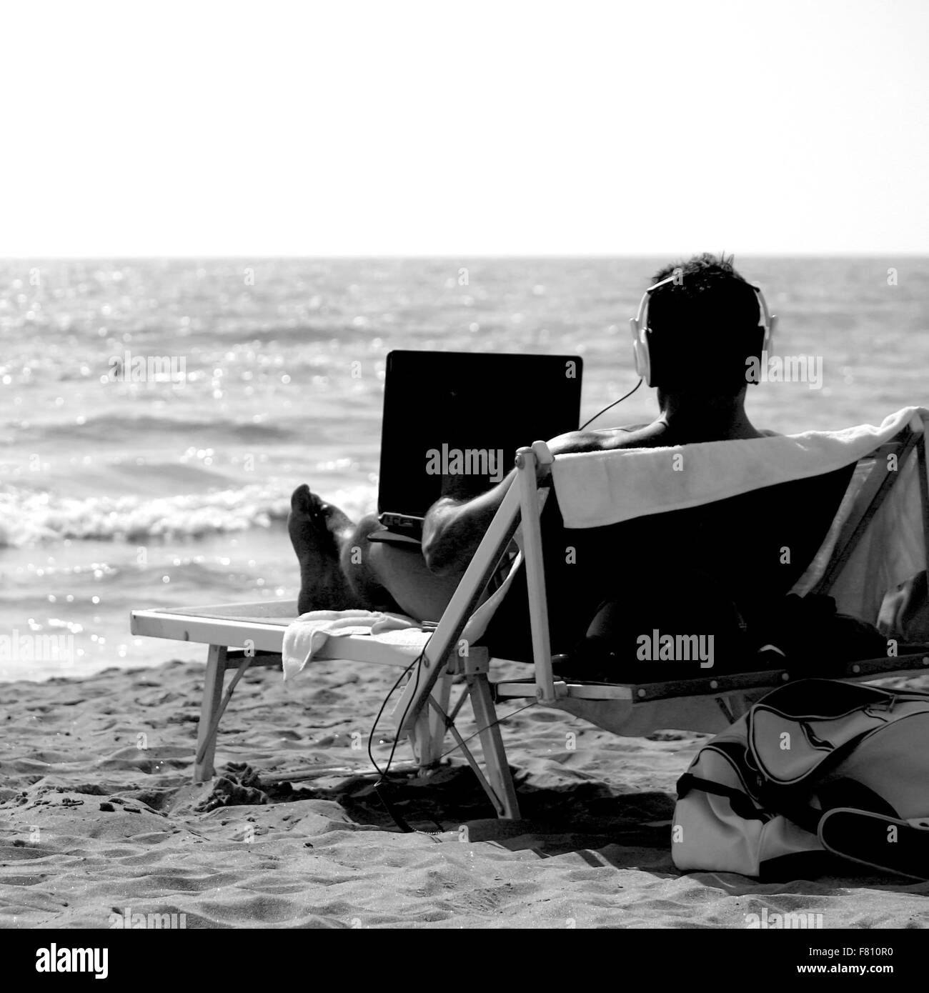 Spiaggia uomo geek rilassarsi e prendere il sole Foto Stock