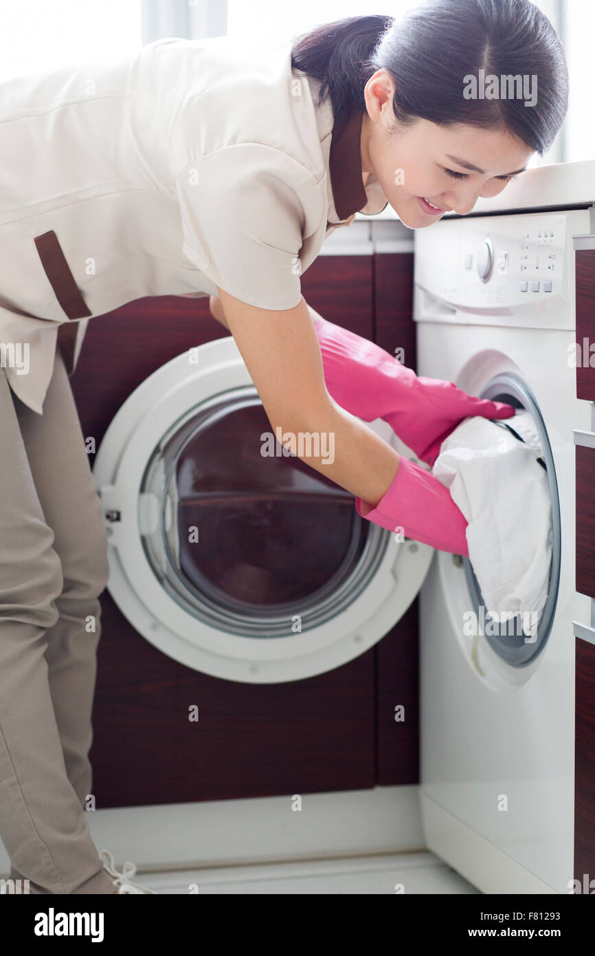 Il personale domestico facendo servizio lavanderia Foto Stock