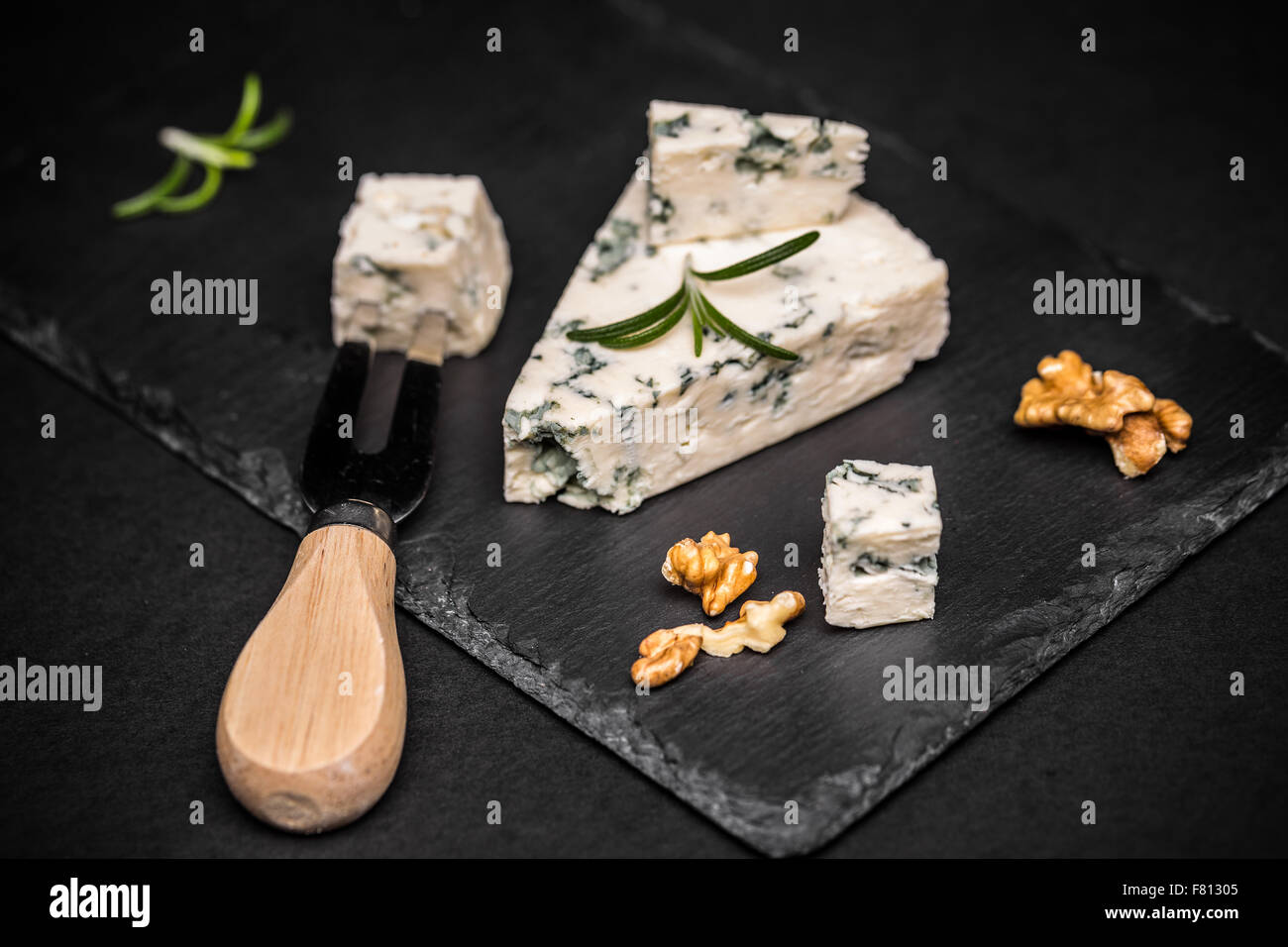 Fette di danese formaggio blu su nero ardesia Foto Stock