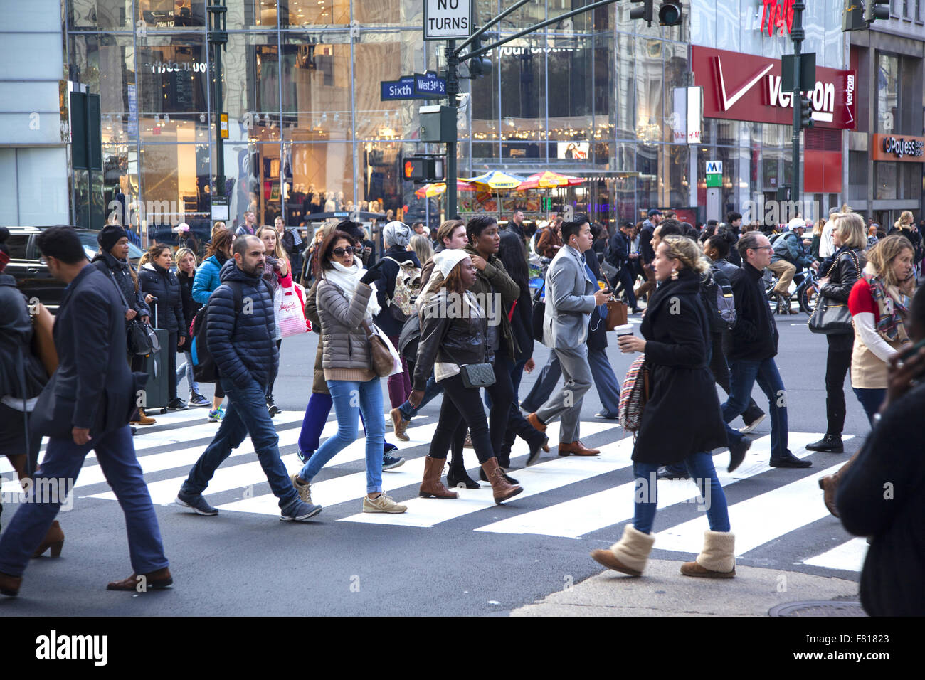 La gente cammina lungo la 34th Street alla 6th Ave. Durante la stagione delle feste di Natale a Manhattan, New York. Foto Stock