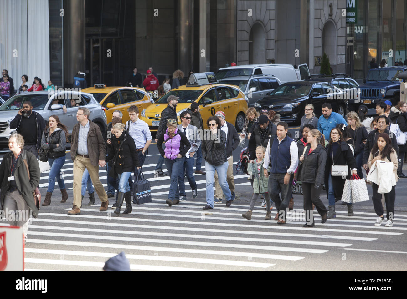 La folla di turisti e amanti dello shopping cross 42nd St. a 5th Ave. sul Venerdì nero all'avvio ufficiale della vacanza stagione di shopping NYC Foto Stock