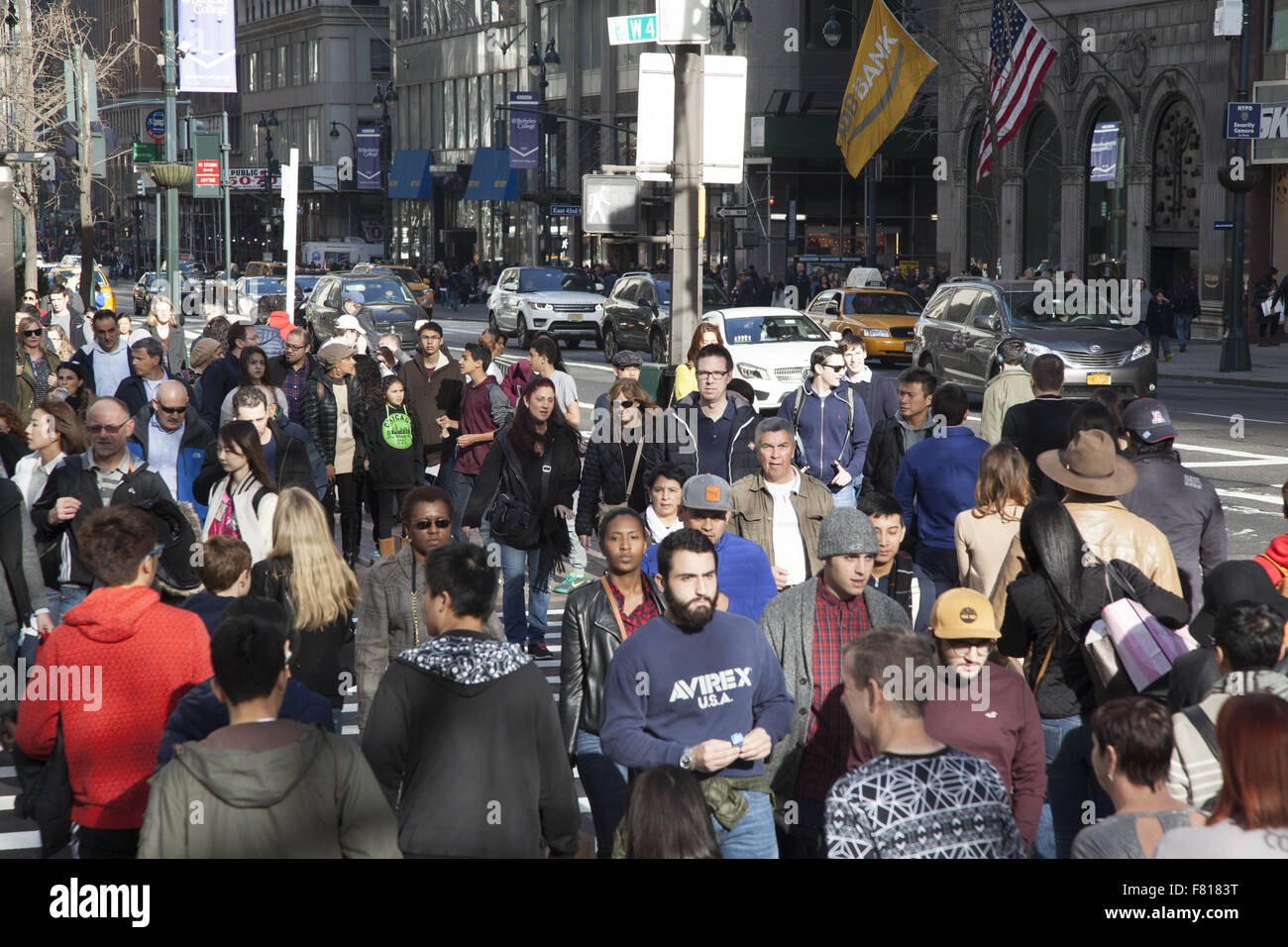 La folla di turisti e amanti dello shopping cross 42nd St. a 5th Ave. sul Venerdì nero all'avvio ufficiale della vacanza stagione di shopping NYC Foto Stock