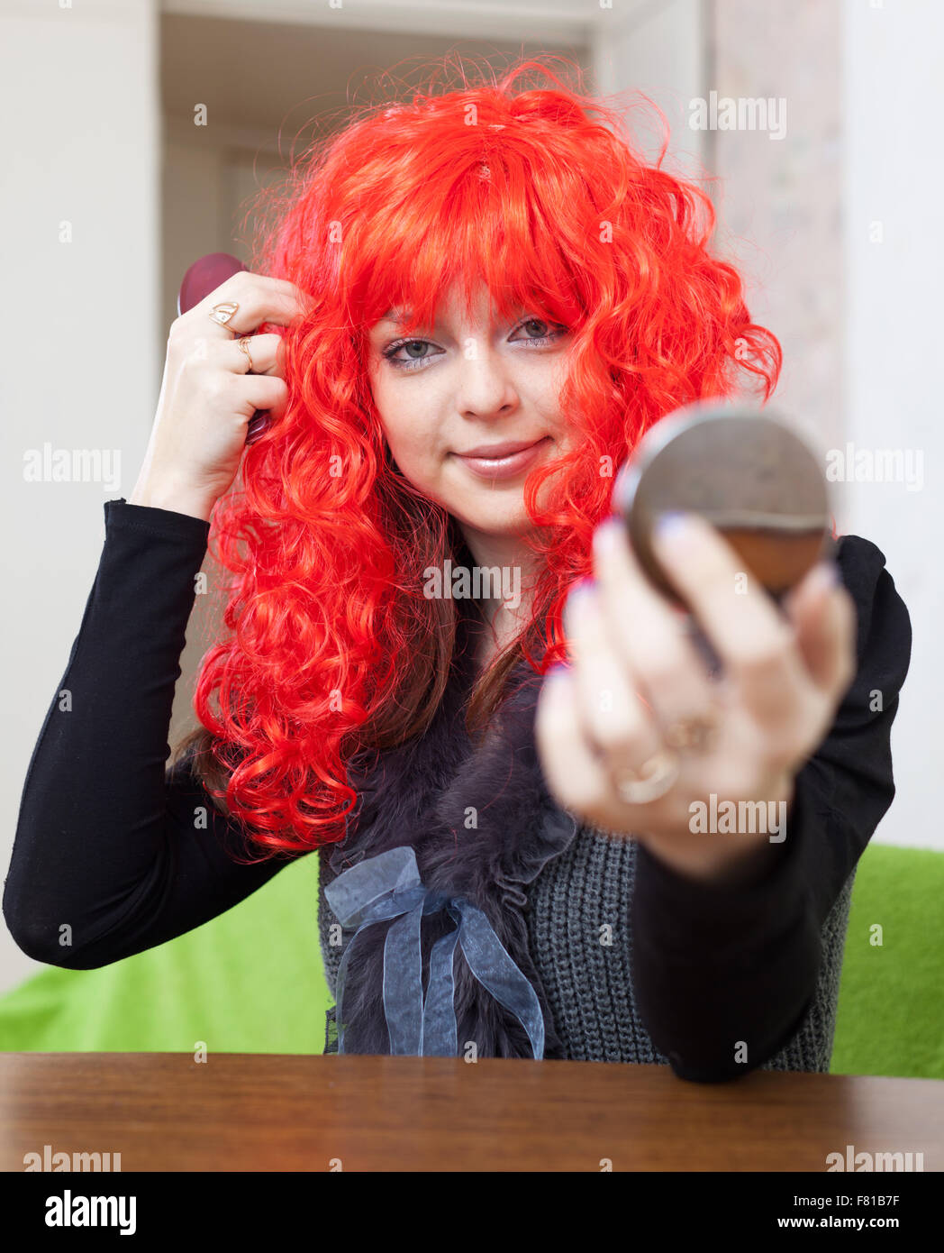 Woman in Red periwig guarda nel retrovisore Foto Stock