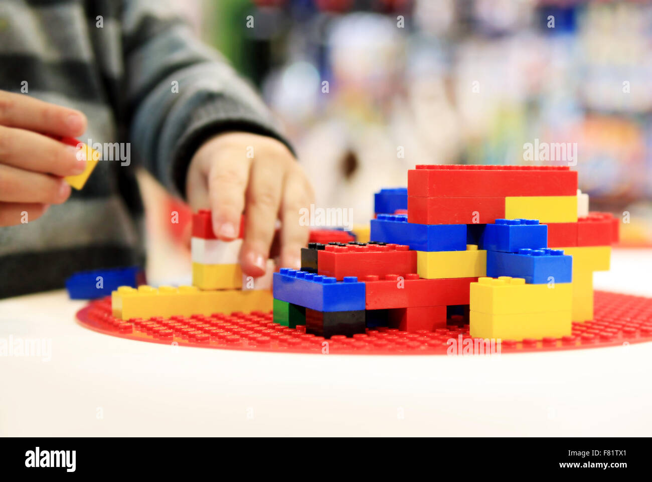 Giocando con LEGO sui treni di creatività per i bambini, la logica, i colori e le dimensioni delle relazioni nonché la formazione bambini bene le abilità motorie. Foto Stock
