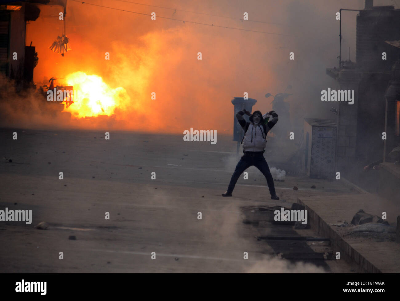 Il Kashmir. 4 dicembre, 2015. Un musulmano del Kashmir protester gesti come una granata stun sparati da poliziotti indiano esplode durante il pro-libertà dimostrazioni nel vecchio Srinagar la capitale estiva della controllata indiana del Kashmir. I manifestanti arrabbiati ha preso la strada principale della zona Nowhatta di vecchi Srinagar e gridò anti India slogan subito dopo il Venerdì di Congregazione la preghiera si è conclusa a Srinagar la Grande Moschea. La polizia ha poi licenziato strappare fumogeni agglomerati in forma di pellets, rivestiti di gomma per i proiettili e granate stun per disperdere pro libertà contestatori. Credito: PACIFIC PRESS/Alamy Live News Foto Stock