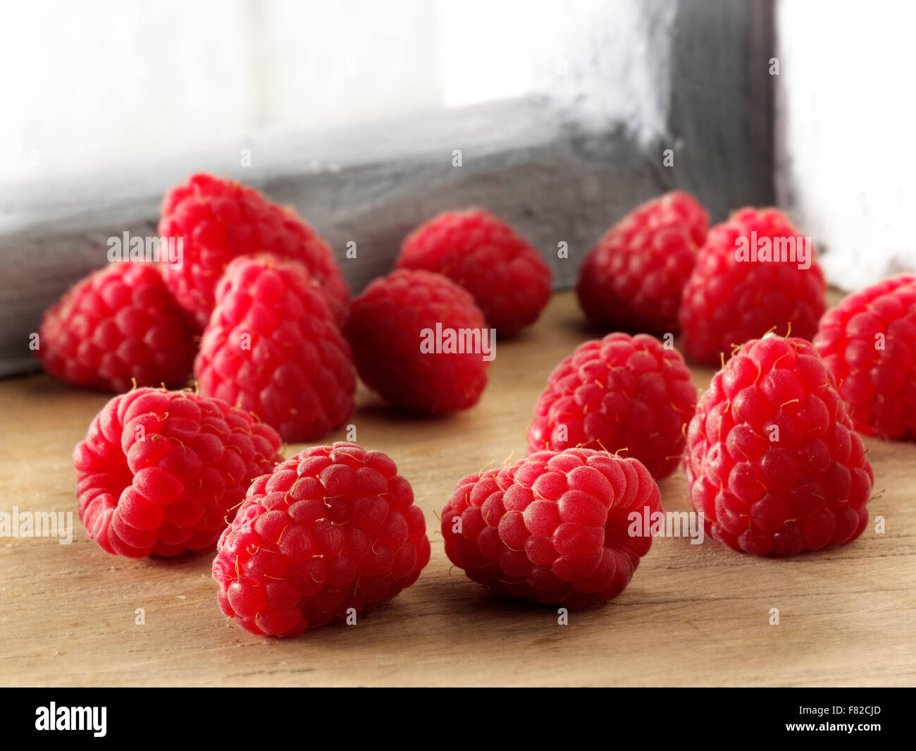 Close up di fresco intero rosso lampone frutti in una impostazione di cucina Foto Stock