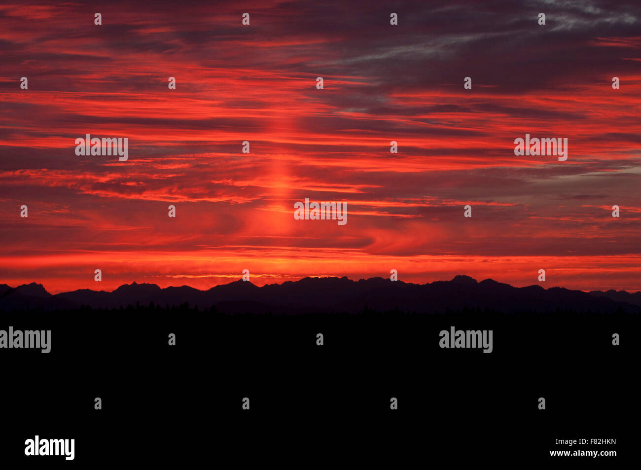 Tramonto sopra le montagne olimpiche con un pilastro Sun fotografato vicino Shelton, WA, Mason County, Stati Uniti d'America. Foto Stock