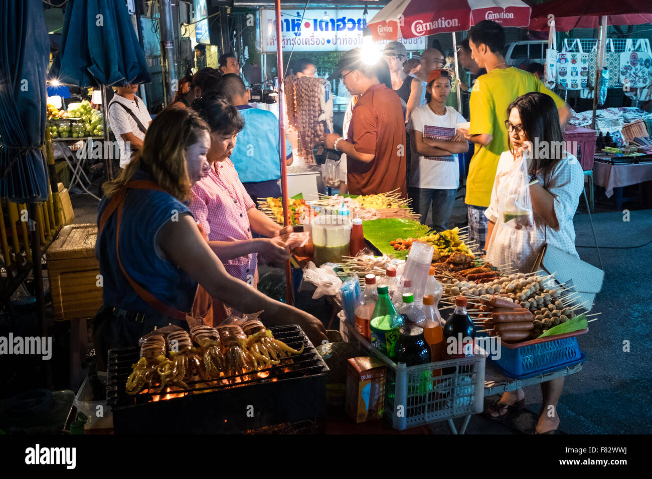 Un cibo in stallo la vendita di carni e pesce alla griglia alla calma e atmosferica a piedi dal mercato notturno lungo Wualai Road a Chiang Mai, Thailandia. Foto Stock