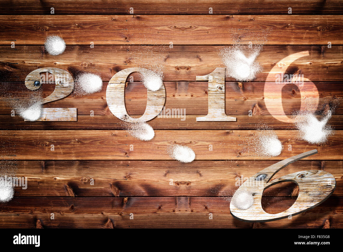 Tavola di legno con l'anno 2016 lettere che viene intonacata con snowballs. Foto Stock