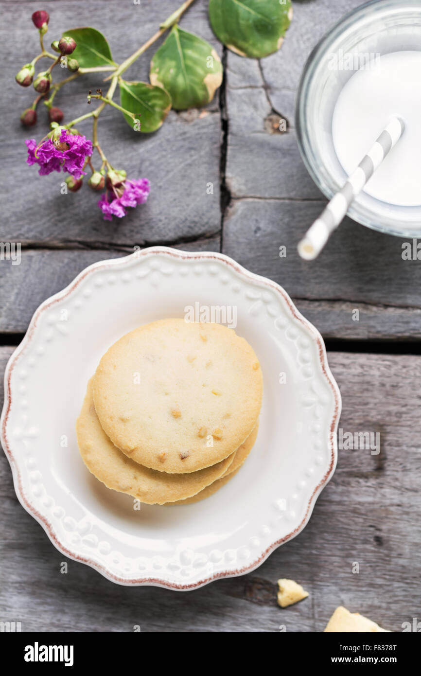 Pila di biscotti di mandorle con un bicchiere di latte Foto Stock