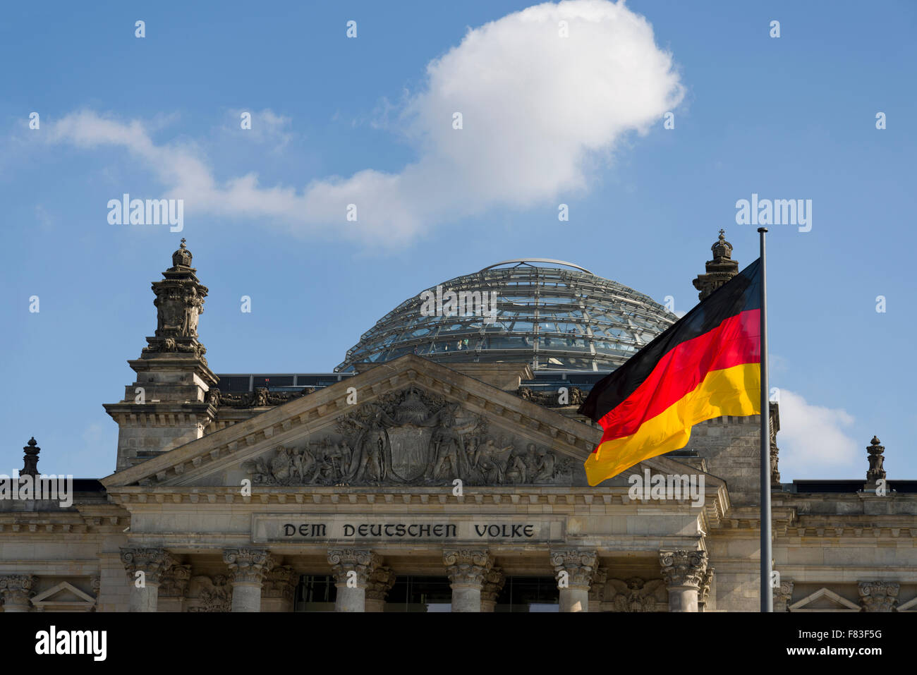 La bandiera tedesca battenti di fronte al Reichstag di Berlino, Germania. Il Parlamento tedesco con cupola di vetro di Norman Foster Foto Stock