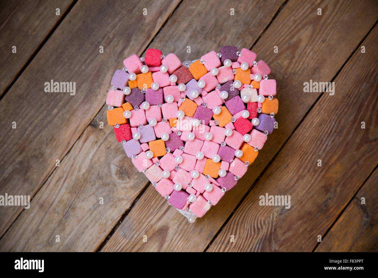 Fatte a mano cuore multicolori con cristalli e gem su sfondo di legno Foto Stock