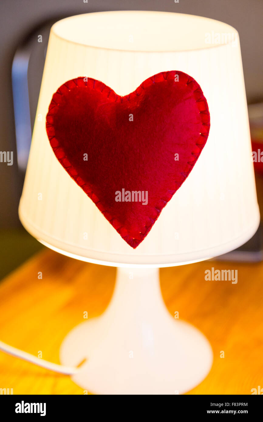 Lampada con cuore rosso realizzati a mano su un tavolo di legno Foto Stock