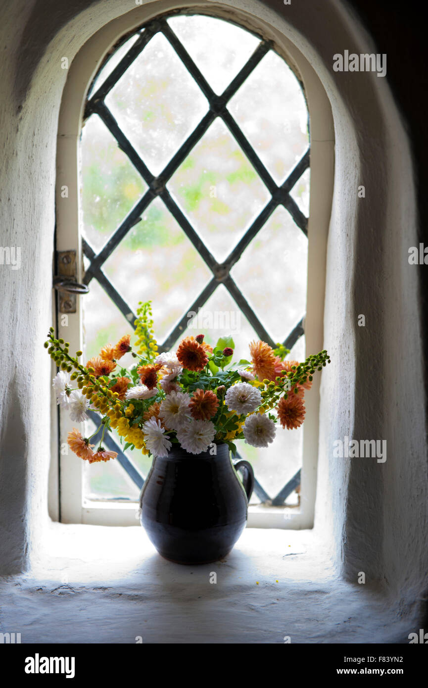Fresco bouquet di fiori in una finestrella medioevale con il vetro al piombo Foto Stock