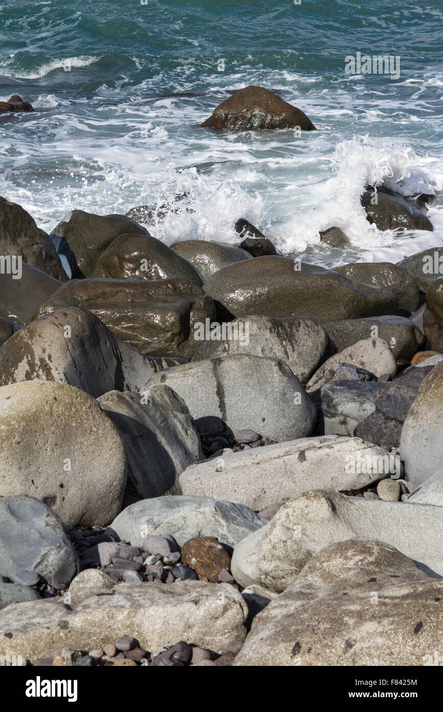 Rocce nere a fascia costiera sull'oceano - spiaggia rocciosa Foto Stock