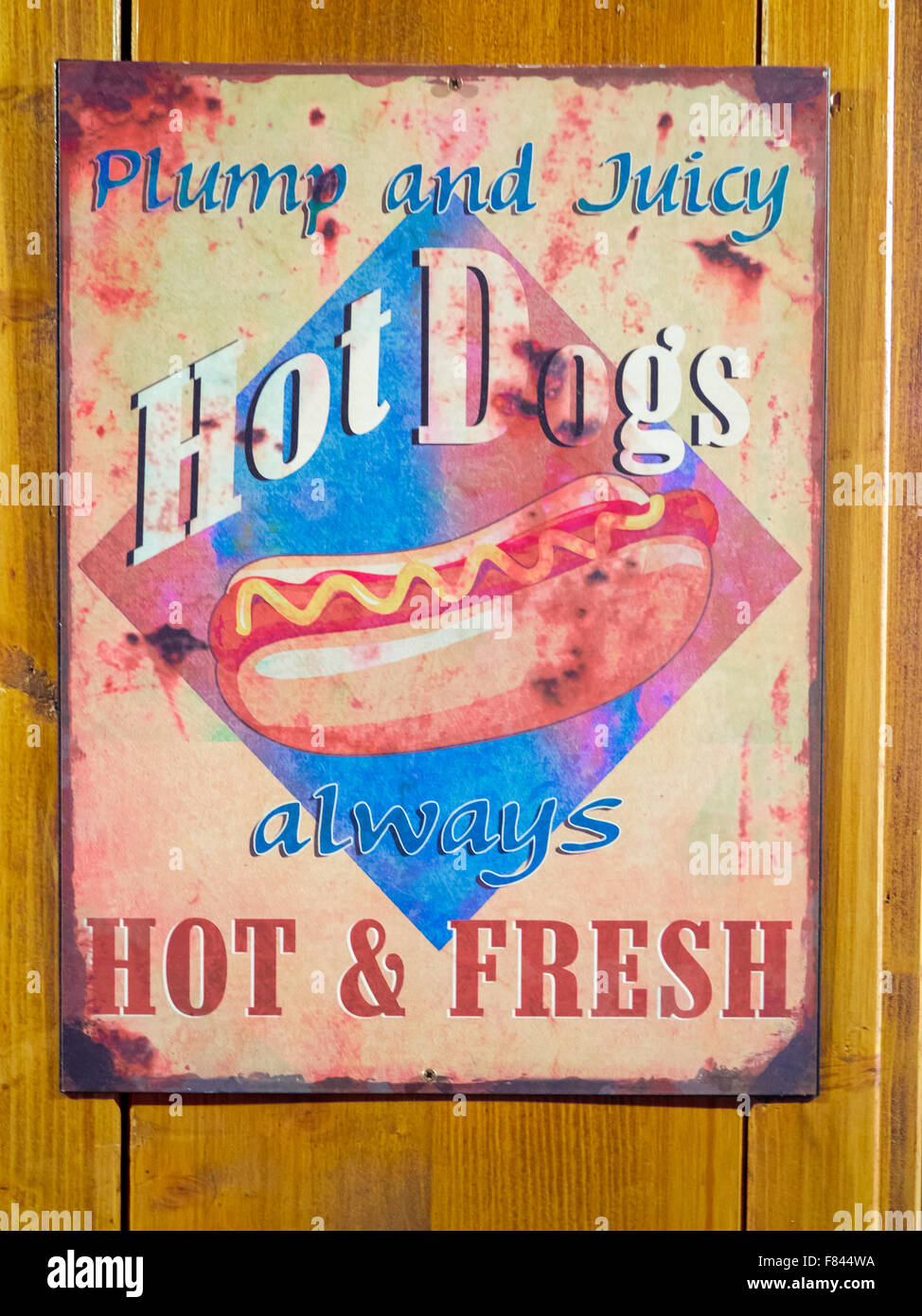 Rusty antica lastra di ferro con la pubblicità di hot dog venditore appeso alla parete in legno Foto Stock Rusty antica lastra di ferro con la pubblicità di hot dog venditore appeso alla parete in legno Foto Stock