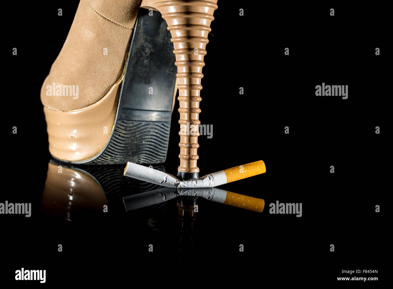 Calzatura donna o tacco pausa sigaretta su sfondo nero Foto Stock