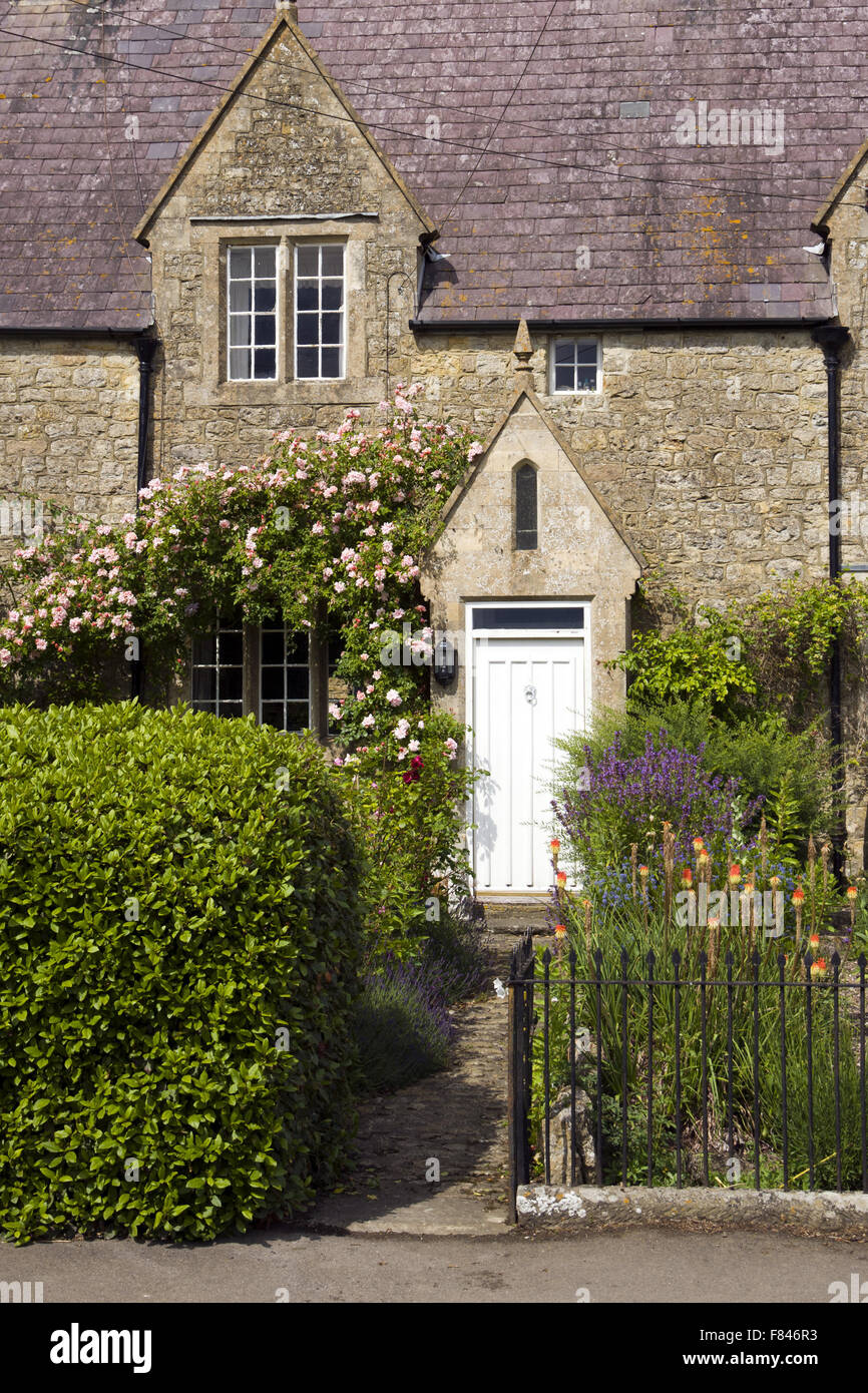 UK real estate. Aprire il cancello del giardino che conduce alla porta anteriore del cottage in pietra. Foto Stock