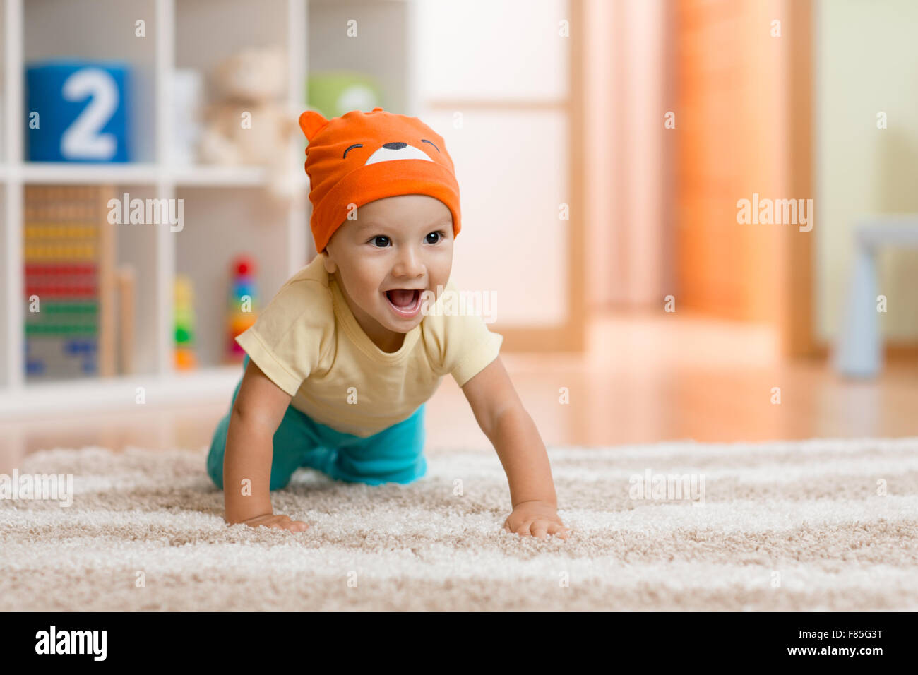Gattona kid o bambino a casa su un tappeto Foto Stock