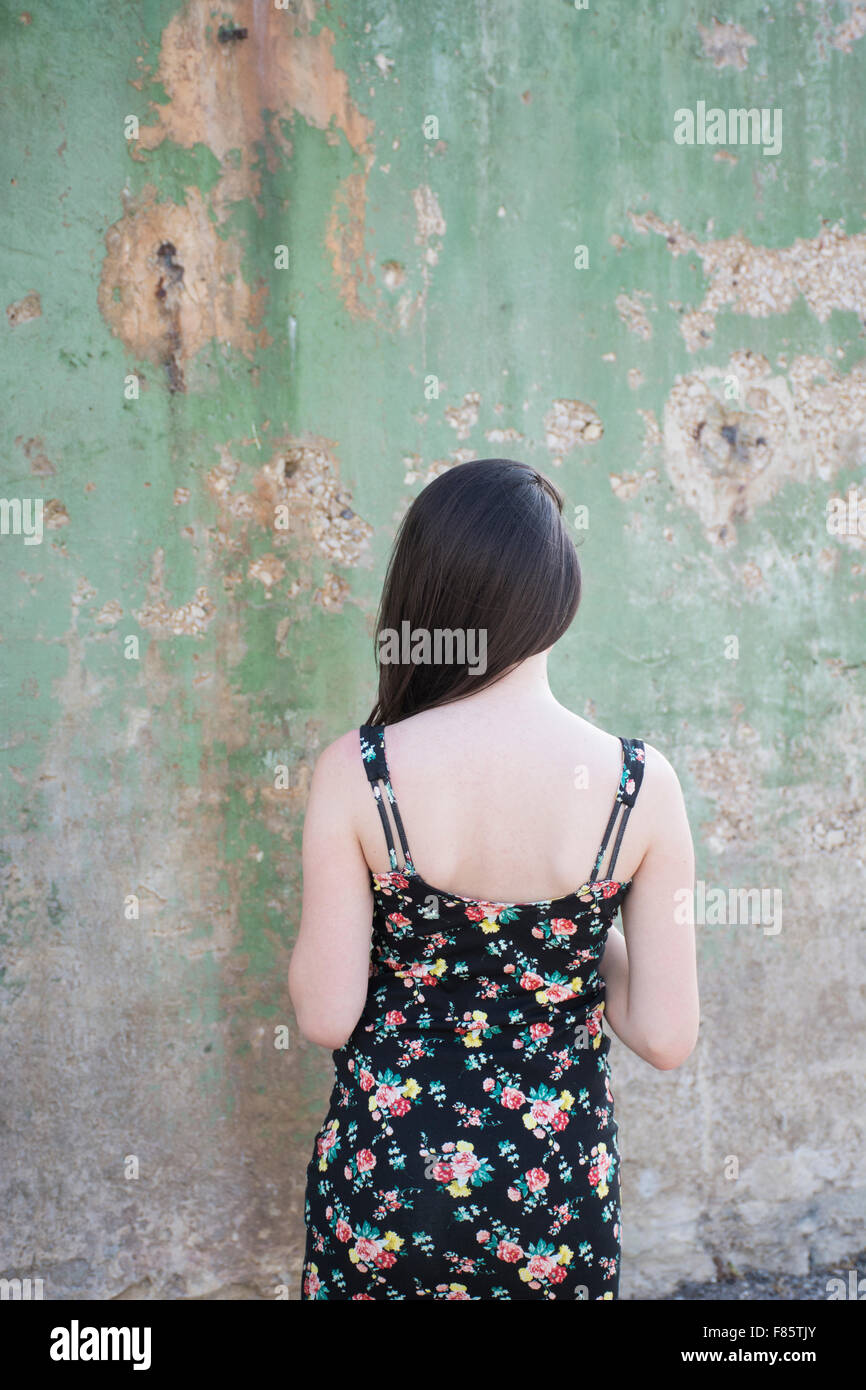 Vista posteriore di un sottile giovane donna che indossa un vestito estivo all'aperto Foto Stock