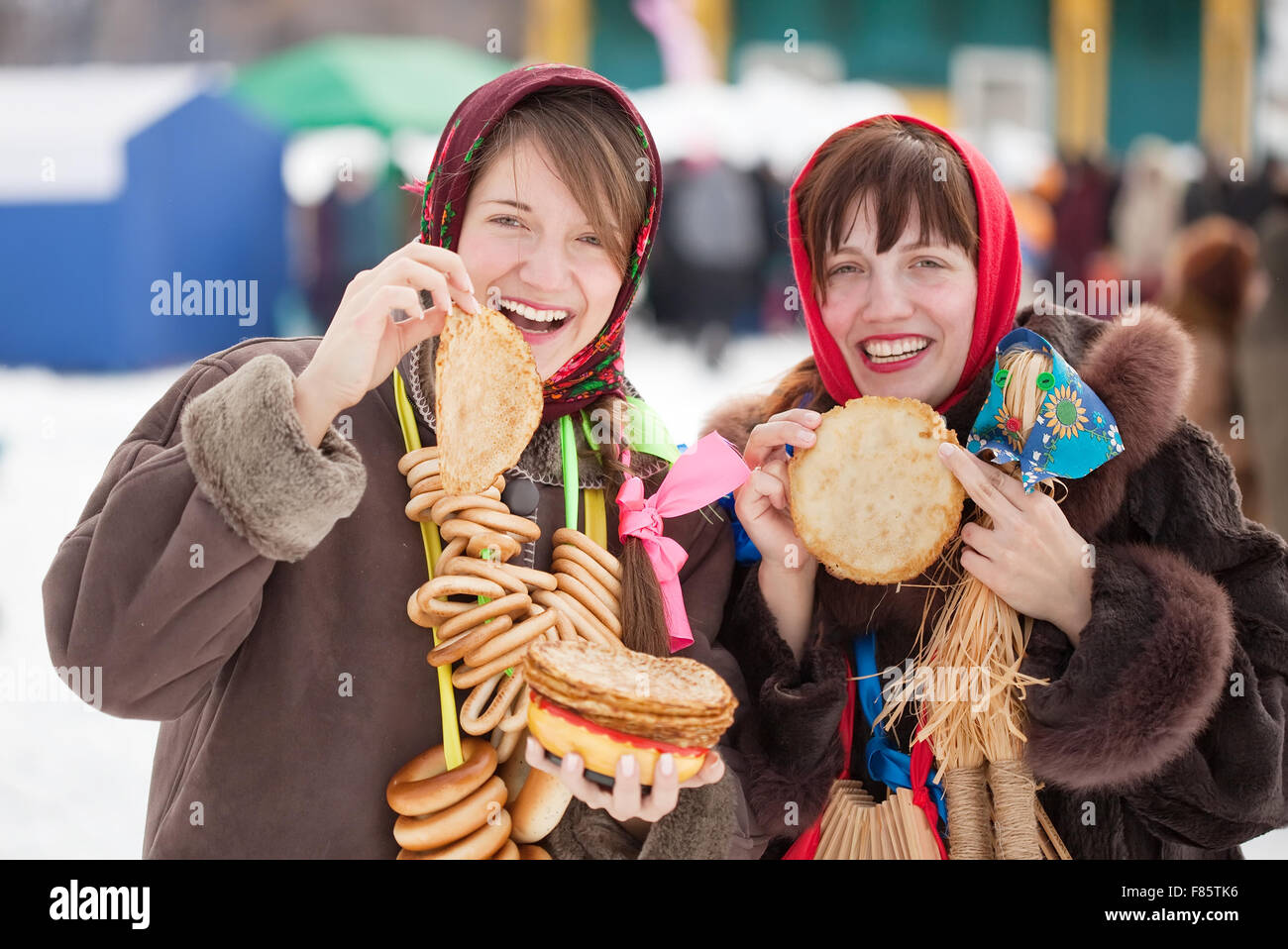 Le donne in abiti tradizionali pancake di degustazione durante Shrovetide Foto Stock
