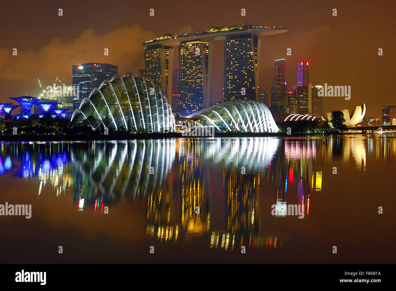 Scena notturna dello skyline della città di Singapore che mostra il fiore Cupola e Cloud Forest cupole e Supertrees Grove nei giardini Foto Stock
