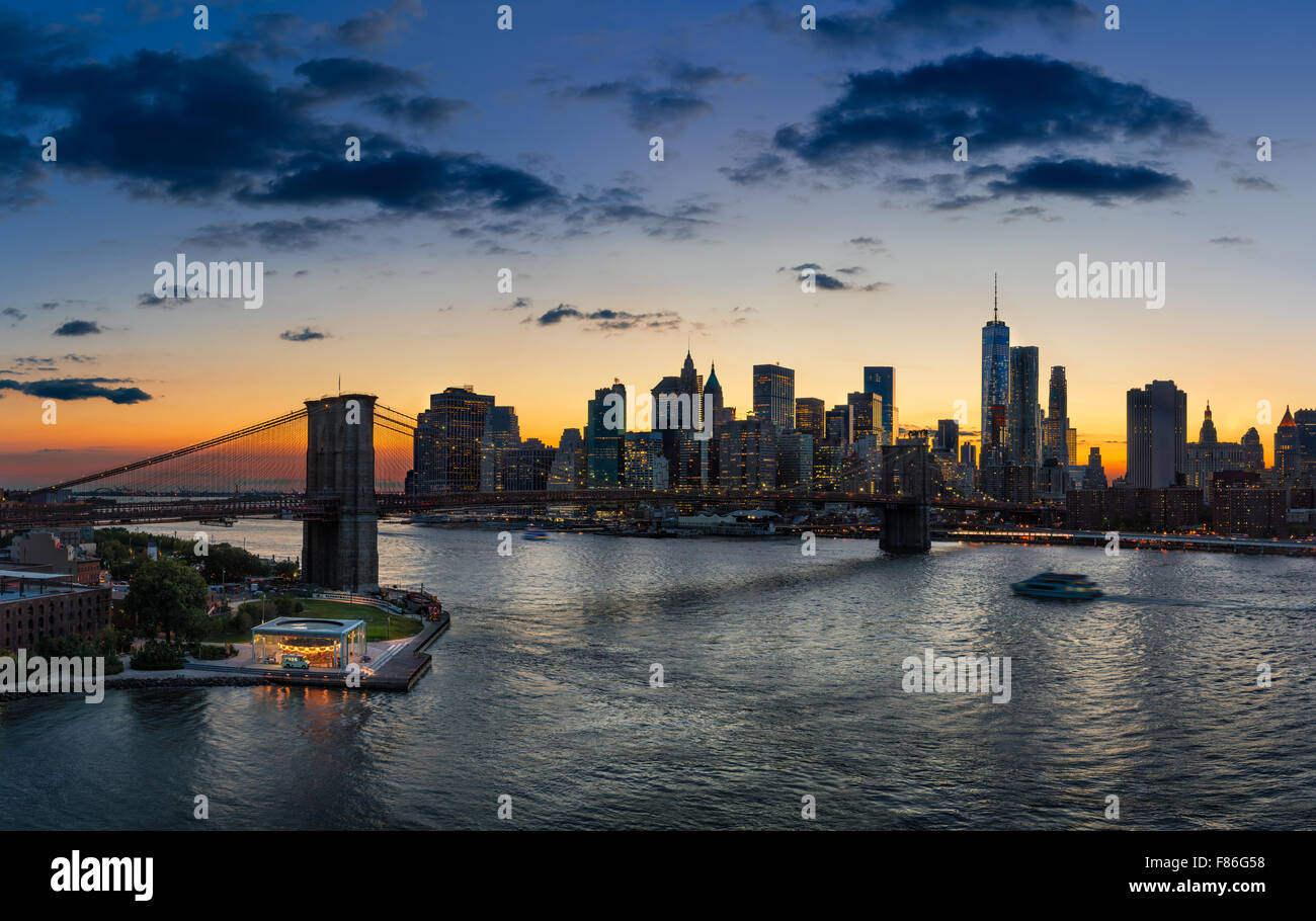 Vista in elevazione del Ponte di Brooklyn, East River, Lower Manhattan, grattacieli e nuvole al tramonto. La città di New York Foto Stock