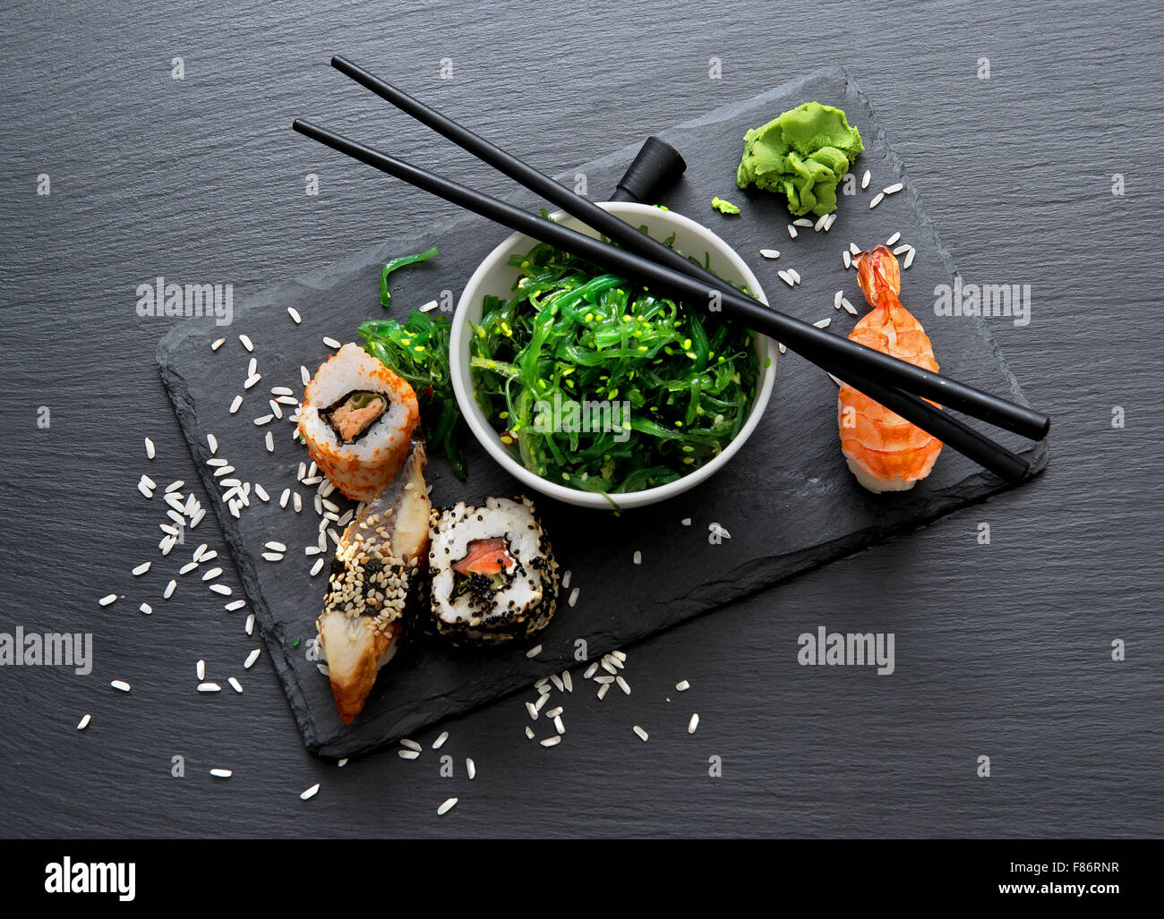 Il Sushi e insalata di alghe marine sulla tavola di ardesia Foto Stock