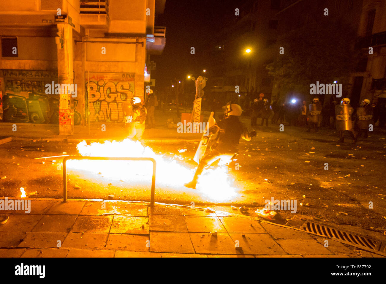 Atene, Grecia. 06 Dic, 2015. Un poliziotto di tumulto genera un gas lacrimogeni bomba contro i rivoltosi, mentre una benzina bomba esplode davanti a lui. Anti-gli autoritari marzo in memoria di Alexis Grigoropoulos, uno studente che è rimasto ucciso da un poliziotto in 6 Dicembre 2008 durante gli scontri. Credito: Kostas Pikoulas/Pacific Press/Alamy Live News Foto Stock