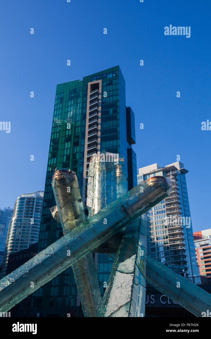 2010 calderone olimpico al Canada Place di Vancouver contro uno sfondo di edifici nel centro cittadino Foto Stock