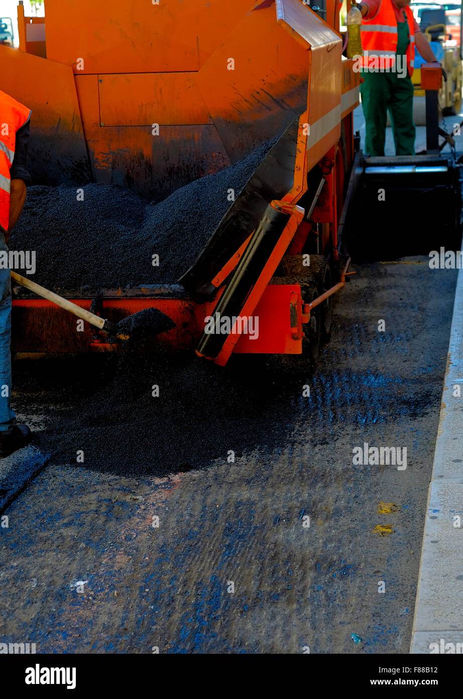 Tracked lastricatore di posa di asfalto fresco durante la riparazione stradale Foto Stock