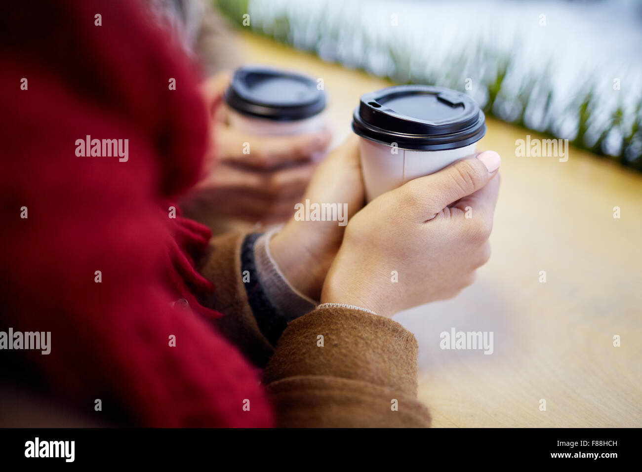 Le mani umane tenendo drink nel bicchiere di plastica Foto Stock